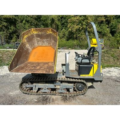 a yellow bulldozer sitting in a gravel lot