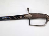 a very old sword with writing on it on a white surface