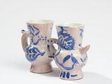 two blue and white vases sitting next to each other