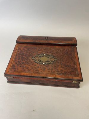 une vieille boîte en bois dont le couvercle est orné d'une décoration en métal