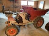 un petit tracteur avec un siège rouge dans un garage