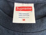 the label on the back of a supreme t - shirt reads, ' pre - shrunk 100 % cotton made in usa '