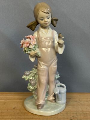 une figurine représentant une petite fille tenant des fleurs