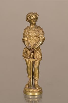une figurine en or représentant un homme portant un chapeau et une robe