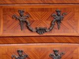 a wooden chest of drawers with a marble top