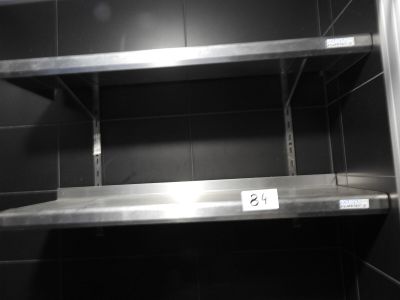 une étagère en métal sur laquelle est accrochée une pancarte, dans des toilettes