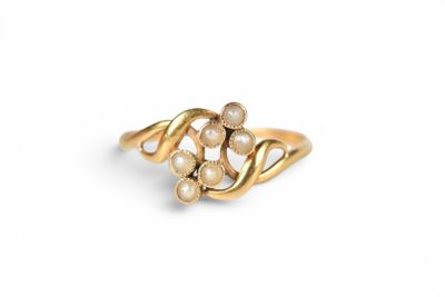 a close up of a gold ring with pearls on a white background