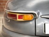 a close up of a car ' s tail light with a brick wall in the background