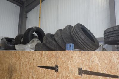Plusieurs pneus sont empilés les uns sur les autres dans un garage.