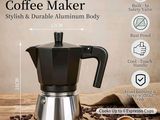 La cafetière moka est posée sur une table, à côté de grains de café