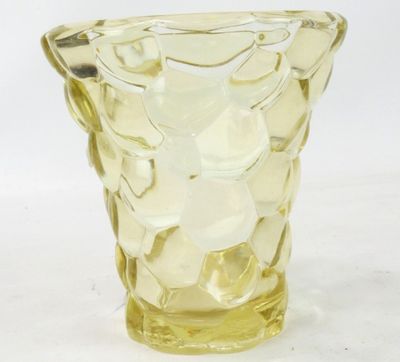 un vase en verre jaune posé sur une table