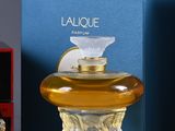 two bottles of perfume sitting next to each other on a table