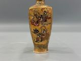 a yellow vase with a floral design on it