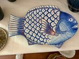 un poisson bleu et blanc posé sur une table, à côté d'une assiette