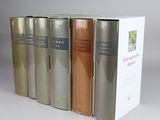three books are lined up in a row on a white surface