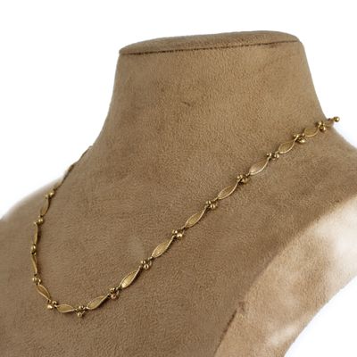un gros plan d'un mannequin portant un collier en or
