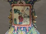 a vase with a painting on it sitting on a table