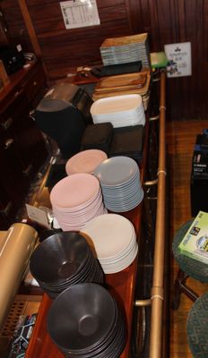 Il y a beaucoup d'assiettes et de bols sur le comptoir de ce restaurant