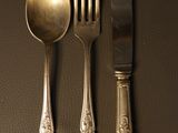 three forks, a spoon, and a knife on a table