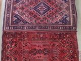deux tapis exposés dans une pièce, à côté d'un miroir