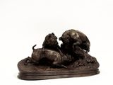une statue en bronze représentant un lion et une lionne sur un rocher