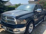 a black ram truck parked in front of a house
