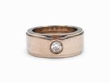 un gros plan sur une alliance en or rose sertie d'un diamant