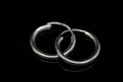 pair of silver hoop earrings on a black surface