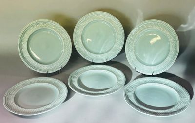Plusieurs assiettes et bols sont alignés sur une table