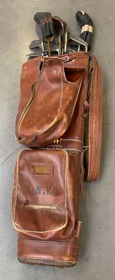 un sac marron contenant des clubs de golf, posé par terre