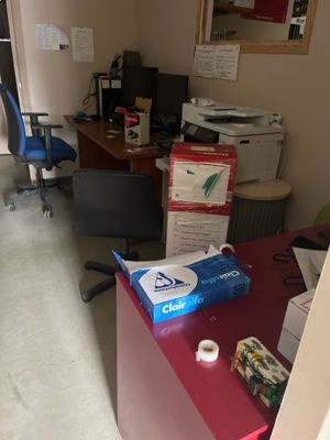 une pièce dans laquelle se trouvent un bureau, une chaise et une imprimante