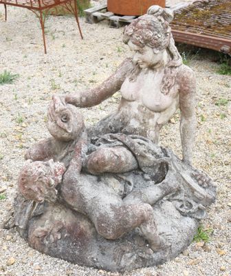 a statue of a woman sitting on top of a rock