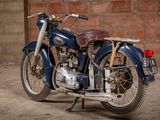 a blue motorcycle that is parked in front of a brick wall