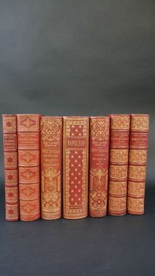 six livres rouges alignés en rangées sur une surface noire