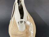 a close up of a straw bag with a bottle in it