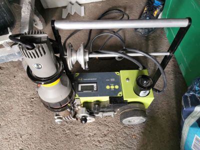 une machine posée par terre à côté d'une poubelle