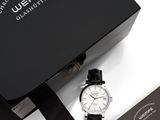 an image of a black and white watch sitting on top of a black box