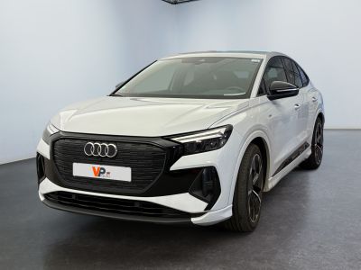 un SUV Audi blanc garé dans un showroom au sol noir