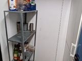 a small kitchen with a blue refrigerator and a metal shelf