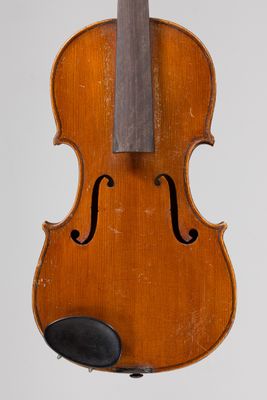 an old violin hanging from a string on a white wall