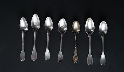 six spoons are arranged in a row on a black surface