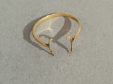 une bague en or à laquelle sont attachées une paire de boucles d'oreilles