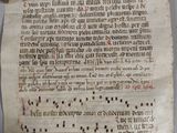 un vieux manuscrit comportant des inscriptions, posé à côté d'une paire de ciseaux