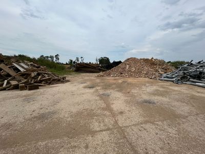 un tas de bois posé au milieu d'un champ de terre battue
