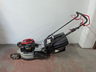 une image d'une tondeuse à gazon garée dans un garage