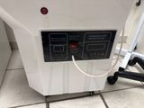 a white machine that is sitting on a tiled floor