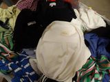 une valise remplie de vêtements et un sac à dos posé par terre