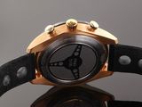 a close up of a watch on a black surface