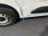 a small white car with a flat tire on the street
