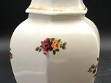 a white vase with pink and yellow flowers on it